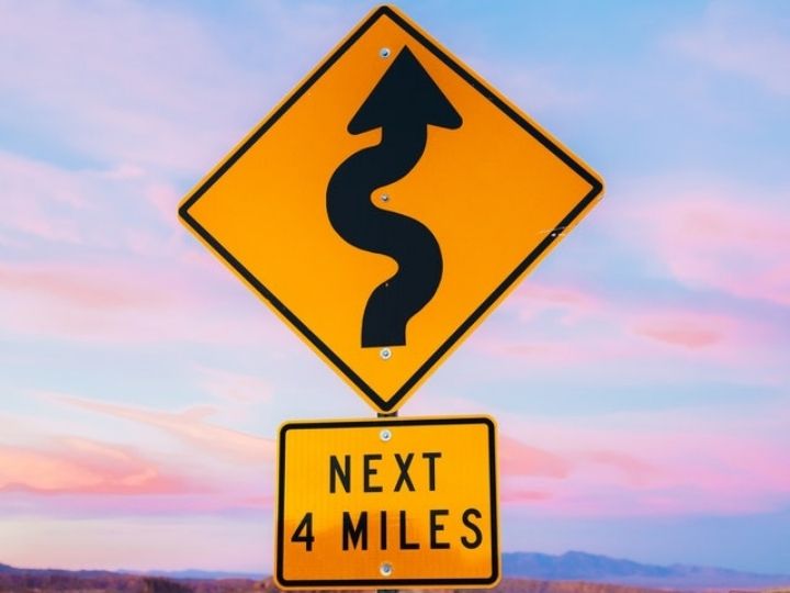 Photo of road sign that warns of curves ahead Photo of road sign that warns of curves ahead