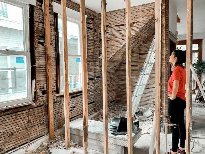 Photo of woman with damaged walls that need re-plastering