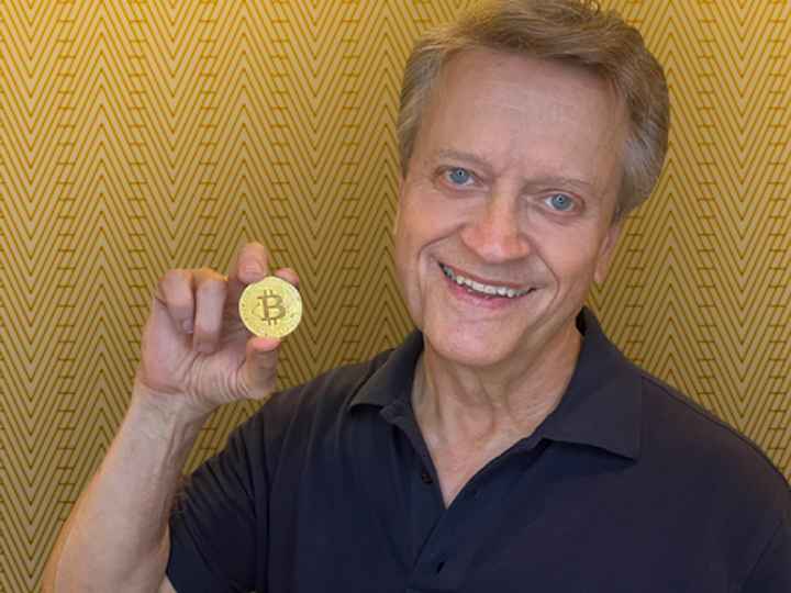 Photo of Professor Snyder holding a Bitcoin token