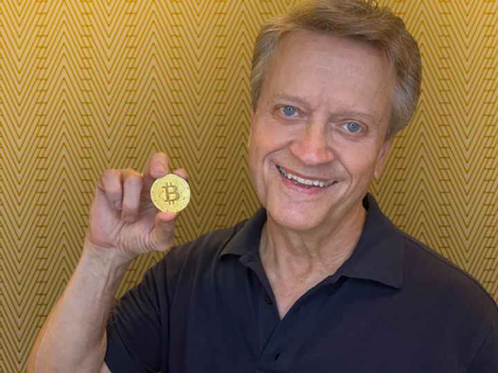 Photo of Professor Snyder holding a Bitcoin token Photo of Professor Snyder holding a Bitcoin token