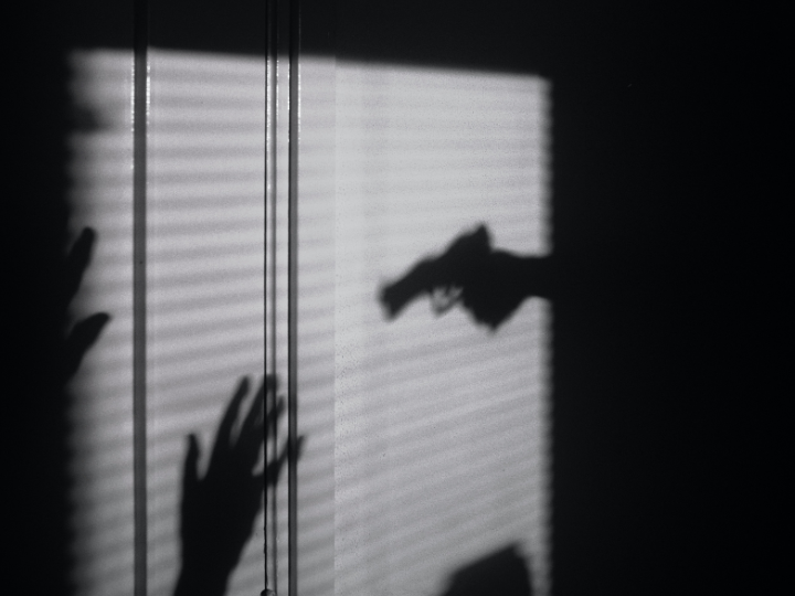 Shadow of gun pointed at someone