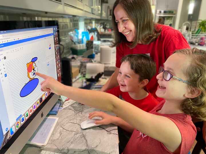 The professor with her young daughter and son at computer The professor with her young daughter and son at computer