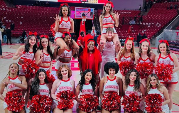 Image of Jackson Lee with UH cheerleaders on basketball court.
