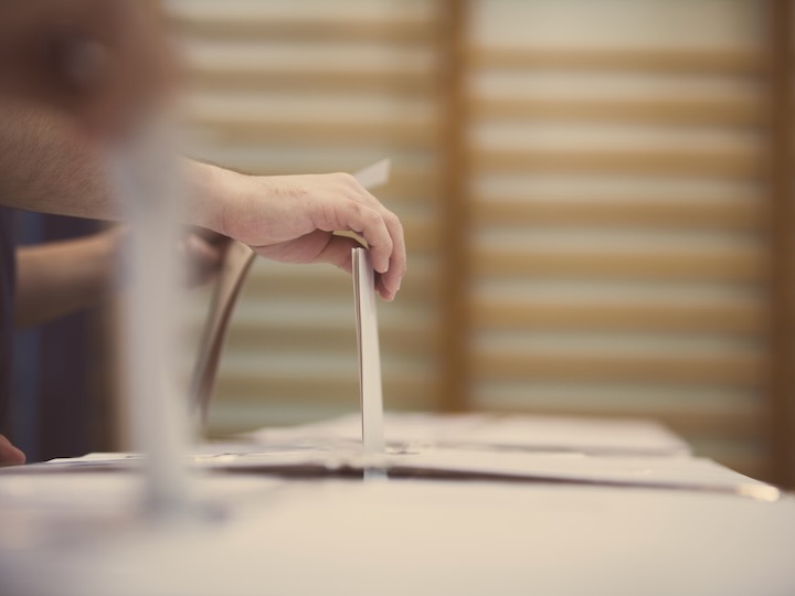 getty image of hand putting a ballot in an election ballot box