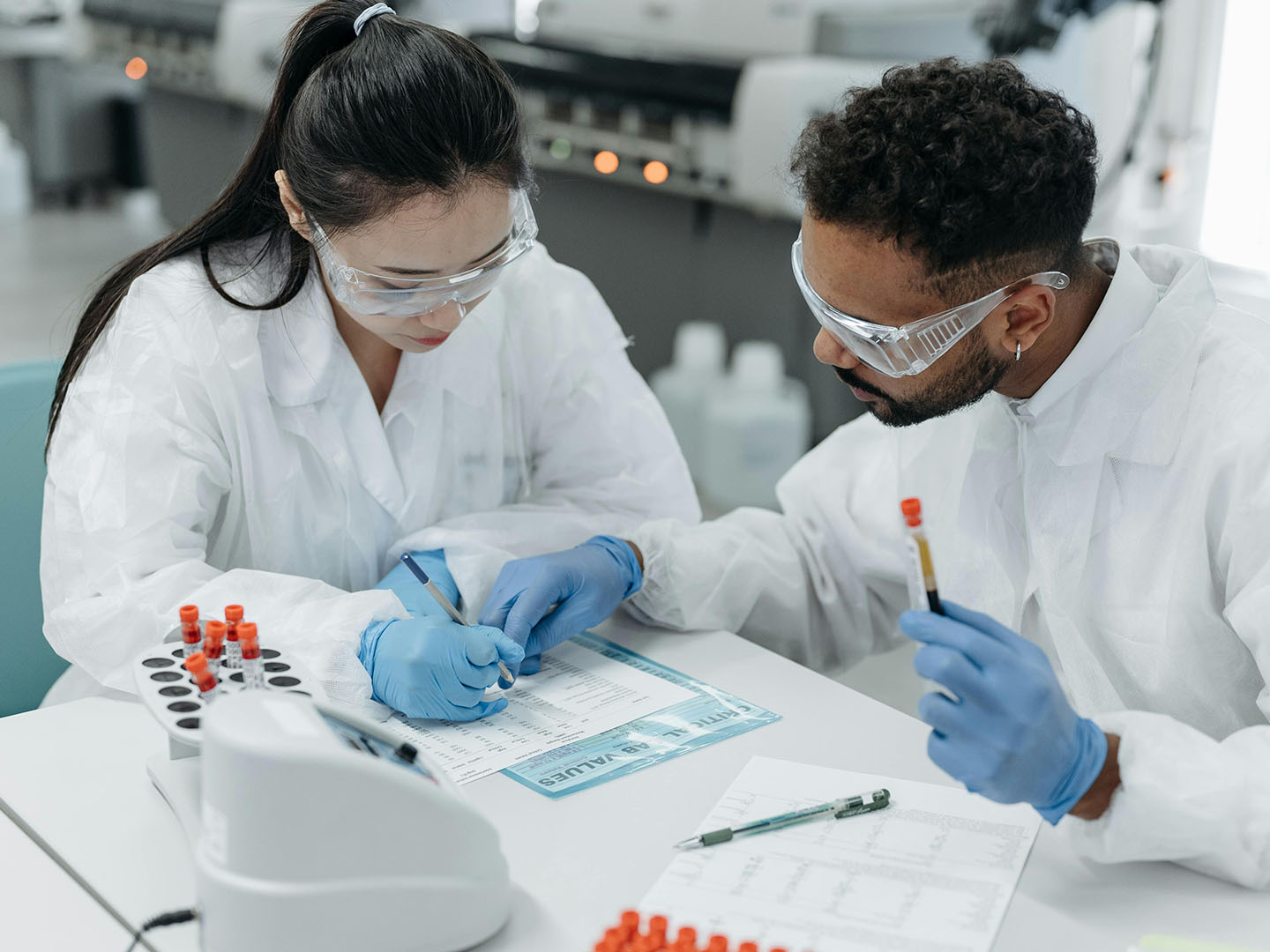Researchers wearing lab coats while looking at documents.