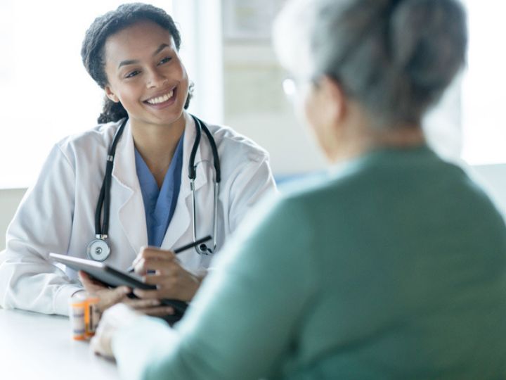 Photo shows doctor using stethoscope to listen to patient’s heartbeat