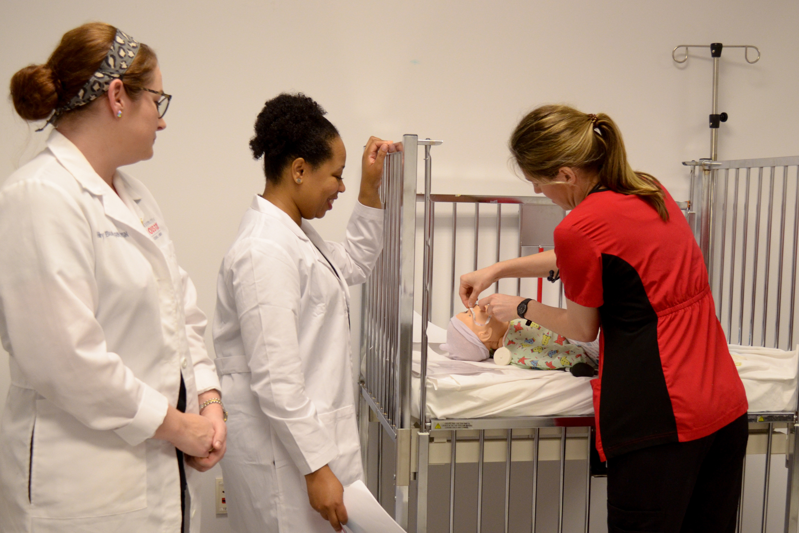 Faculty and nursing student with baby simulator
