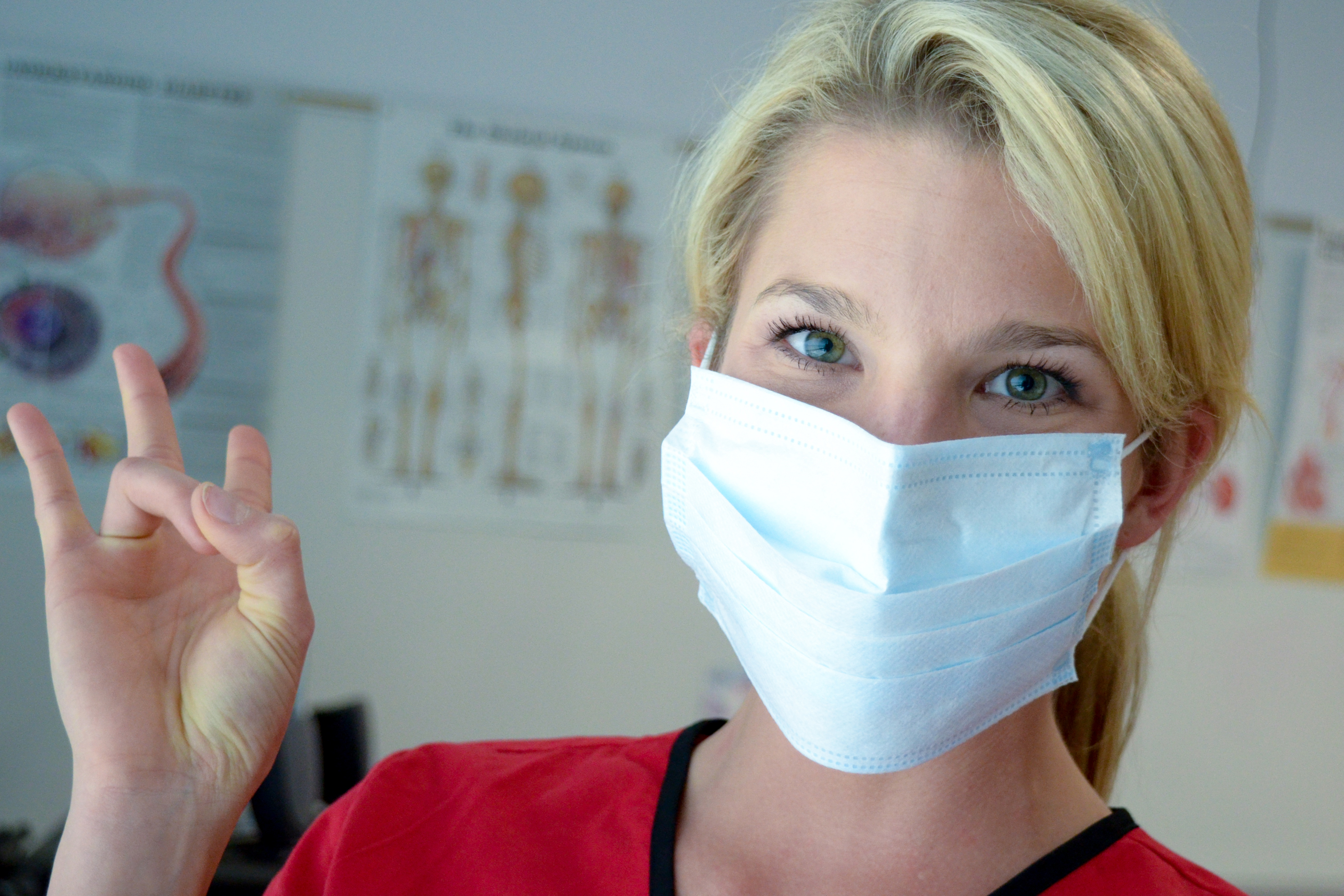 Nurse with mask making Go Coogs handsign