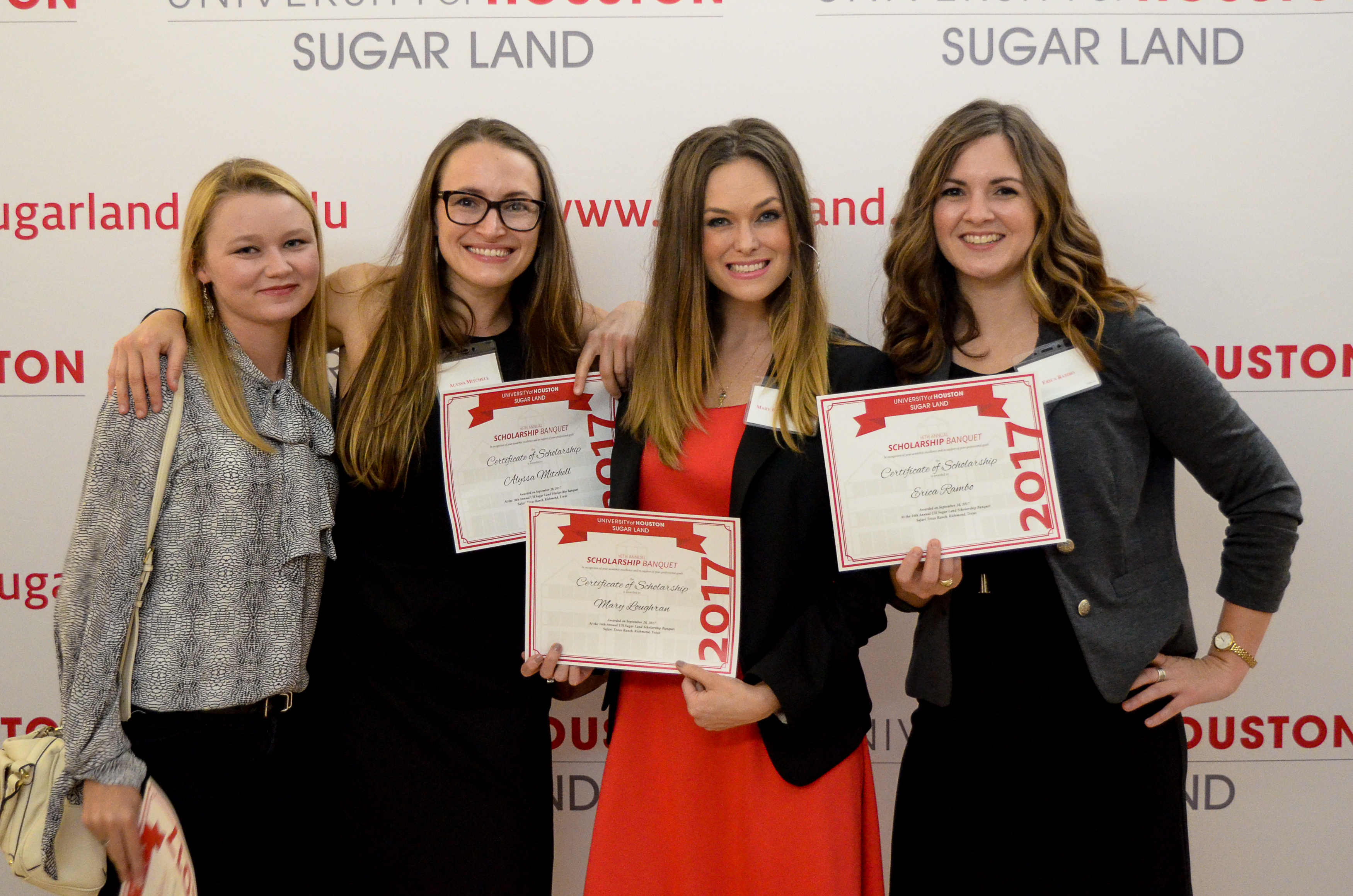 Four students holding scholarship certificate