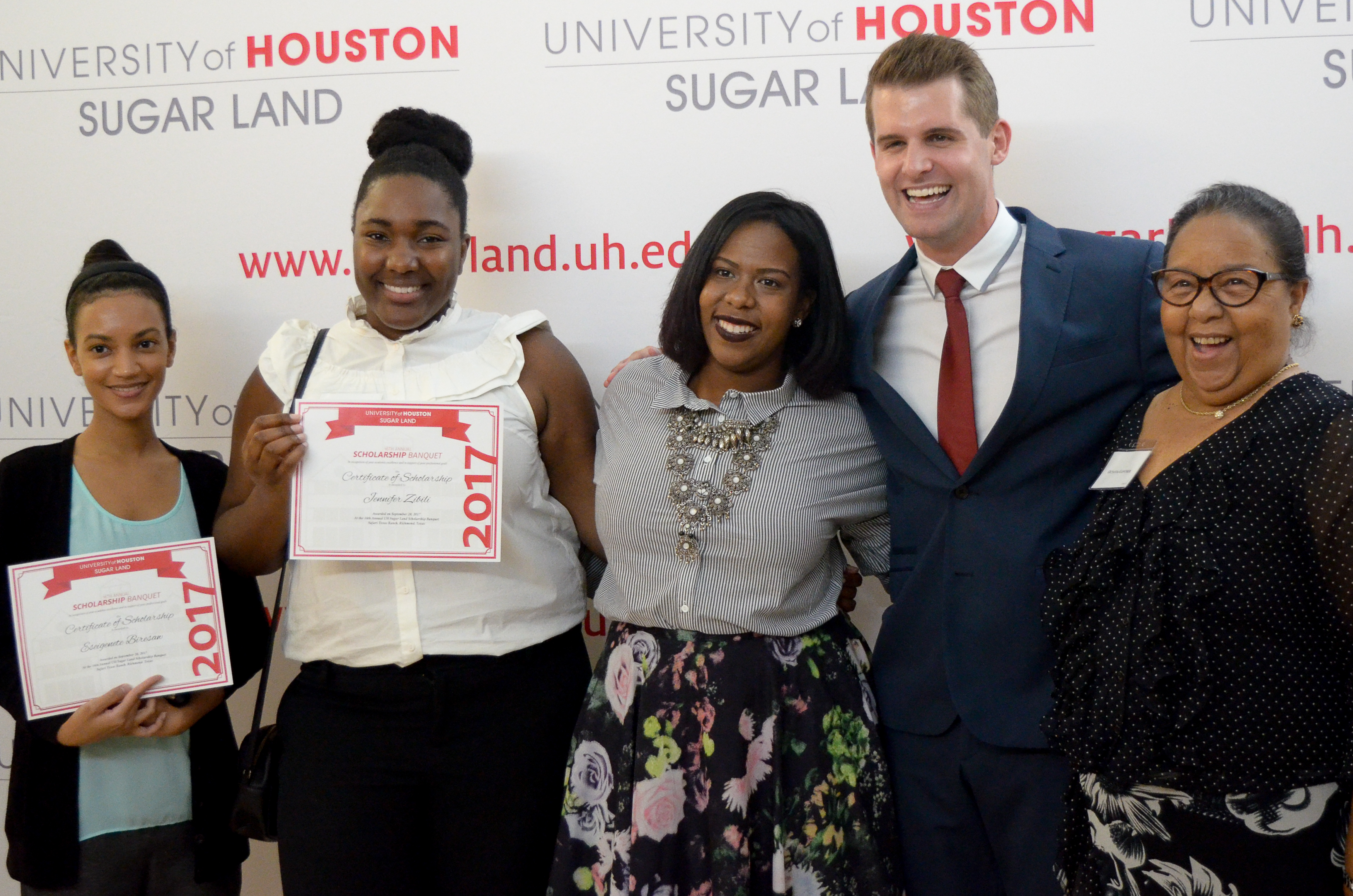 Five students holding scholarship certificates