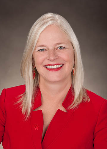 Portrait of a blonde woman wearing a red business jacket