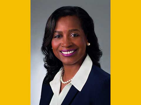 Portrait of a Black woman smiling wearing a business jacket.