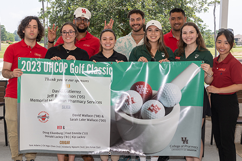 students holding banner at golf tournament