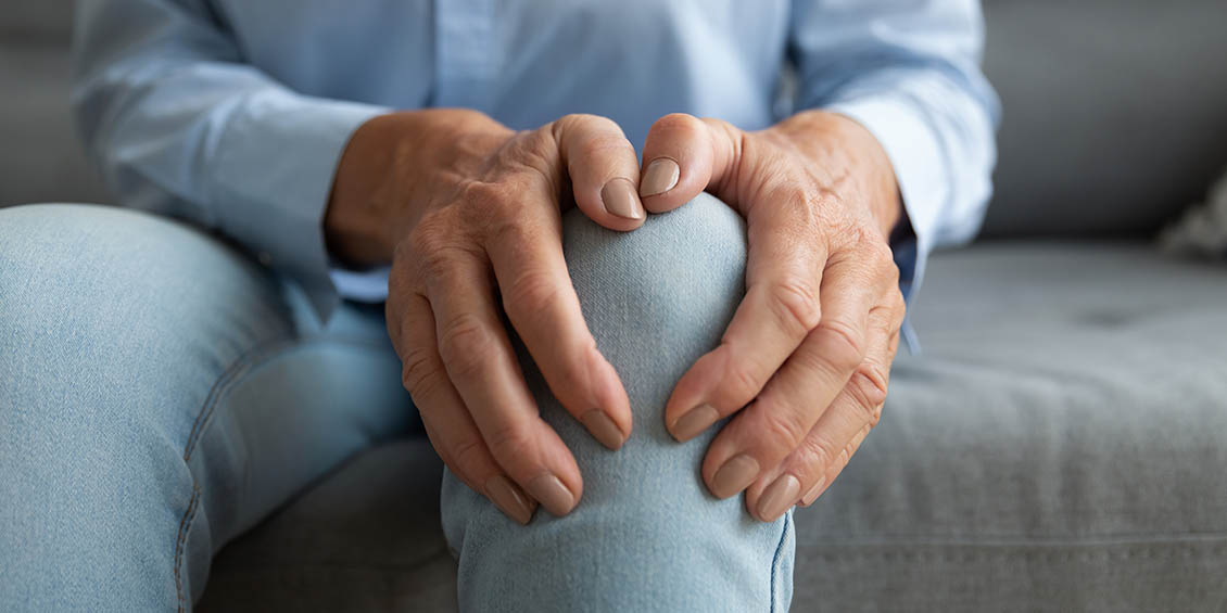 photo of person holding knee in pain