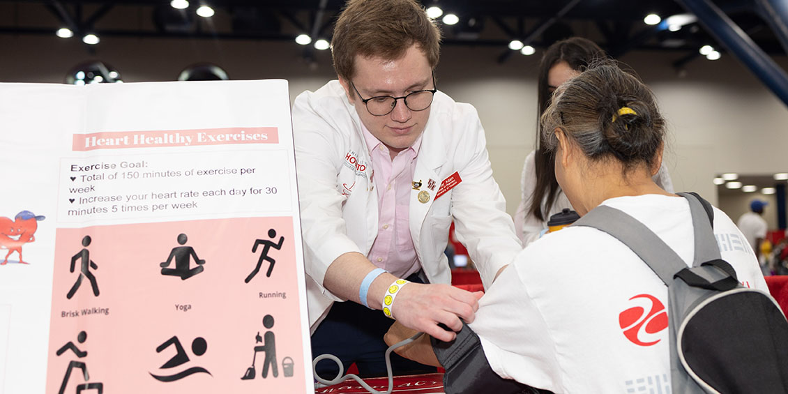 Student Hunter Adam from HPSA takes the blood pressure of event attendee
