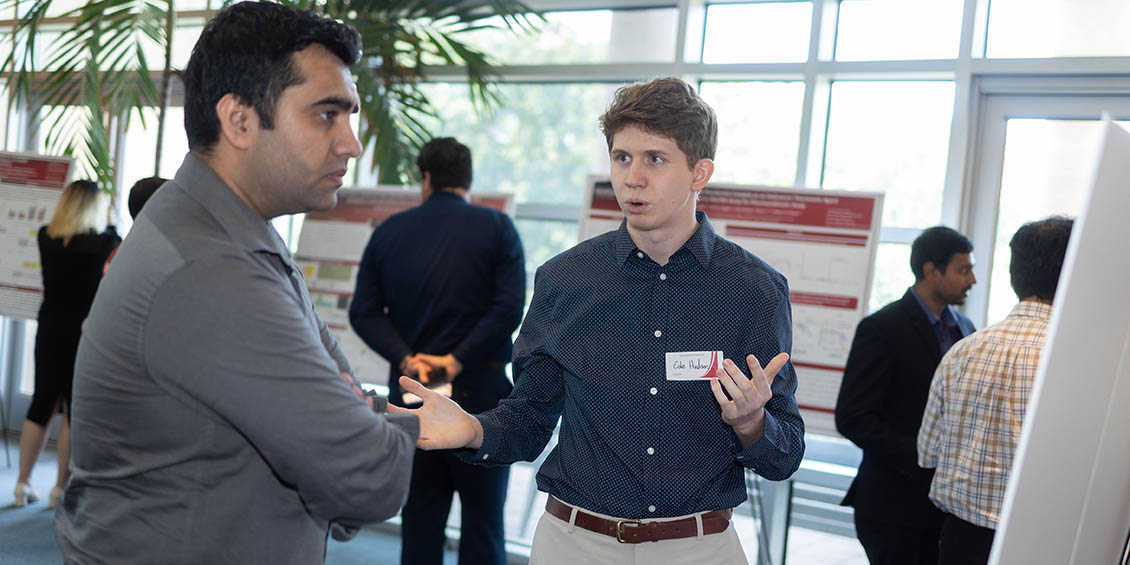 student discussing research poster