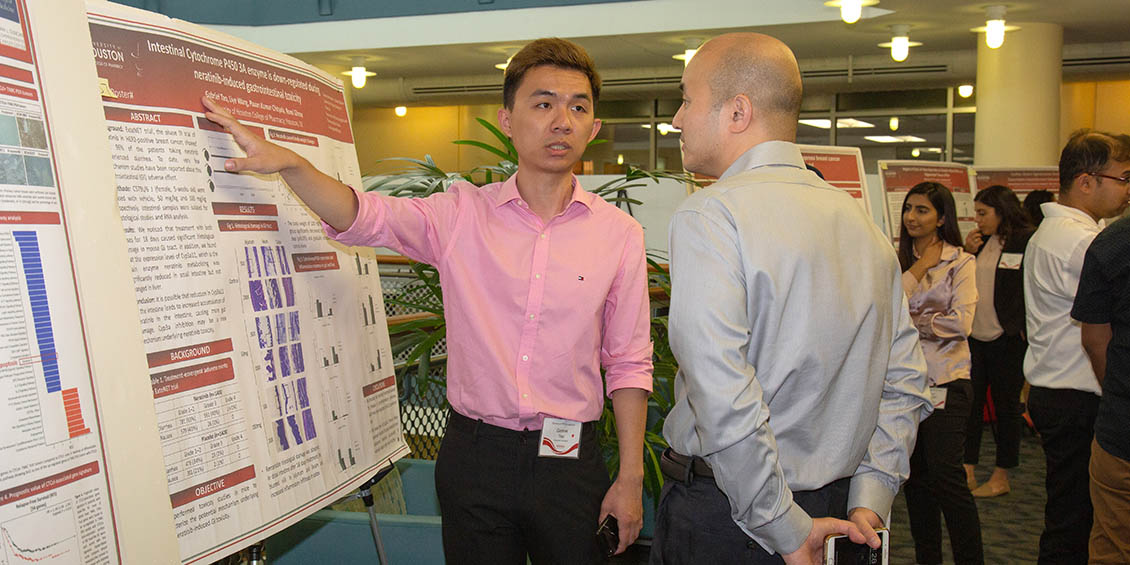 student discusses research poster