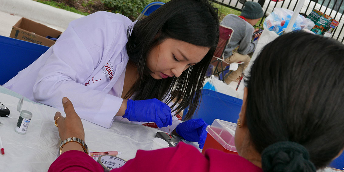 student performs wellness screening to event attendee