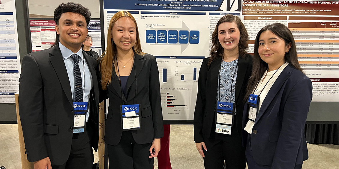 Pharm.D. students standing next to poster