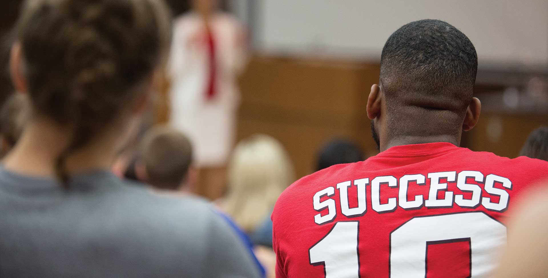 student in classroom with success printed on t-shirt