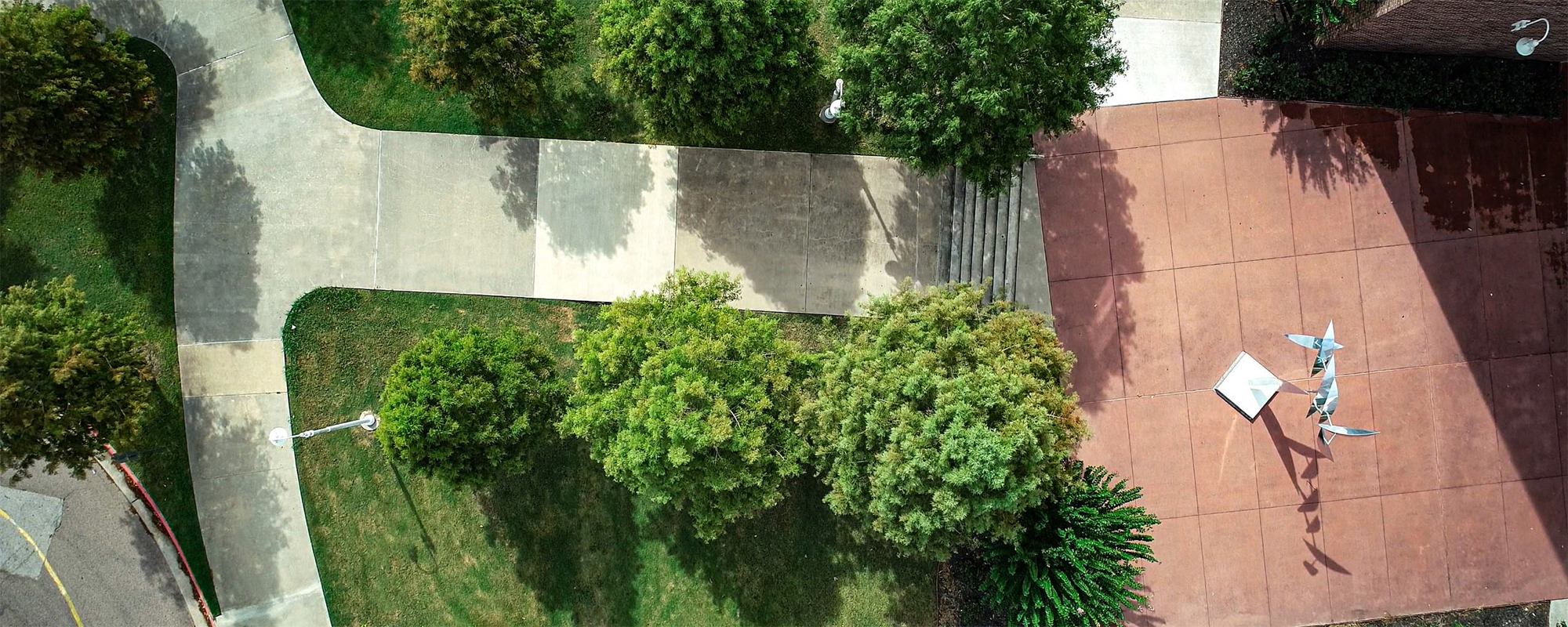 Overhead view of sidewalks and scultpure outside Brazos Hall