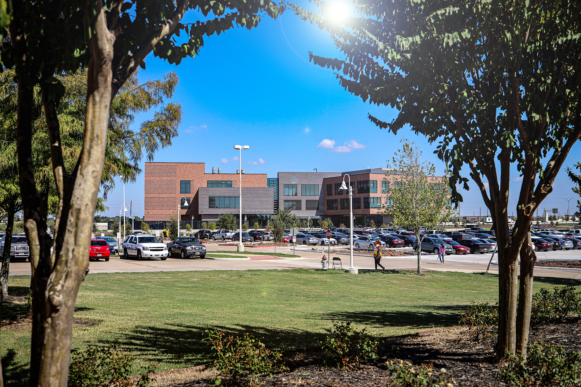 Landscape photo of a three story building framed by two trees