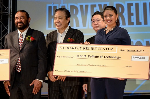 Three men stand behind a woman holding an over-sized check