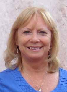 Portrait of a blonde woman wearing a blue top