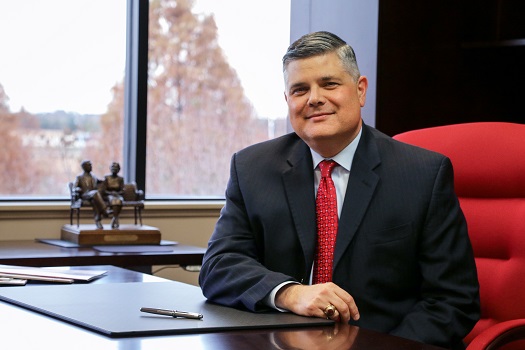 A man wearing a suit sitting at desk