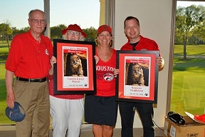 A group of people wearing red shirts holding framed awards