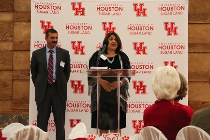 A couple stand on stage speaking to an audience