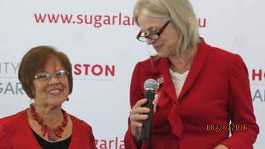 Two women in read stand next to each other
