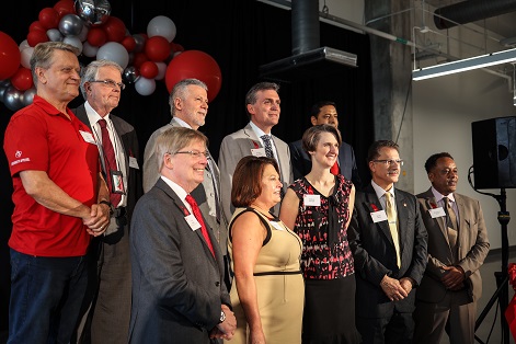 A group of men and women stand together on a stage