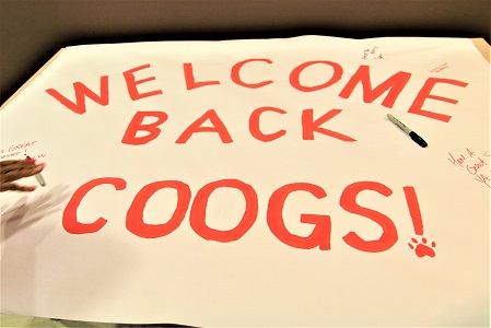 A large paper banner with the words 'Welcome Back Coogs!' and signatures