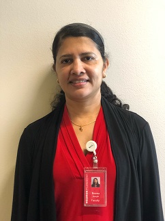 Portrait of a woman wearing a red and black outfit and a name badge