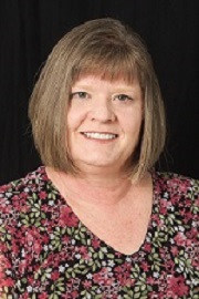 Portrait of a light brown-haired woman wearing a floral top