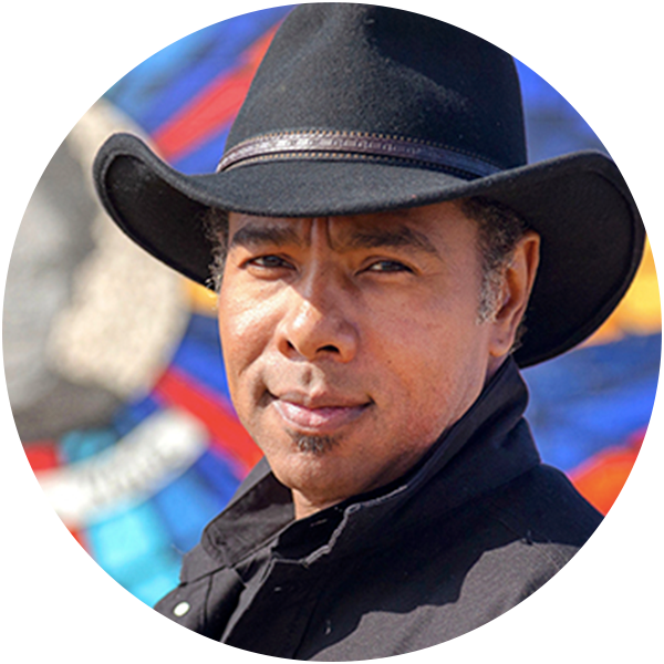 Portrait of a man wearing a cowboy hat in front of a colorful mural