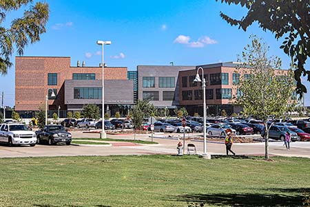 Landscape photo of a large three story brick building.