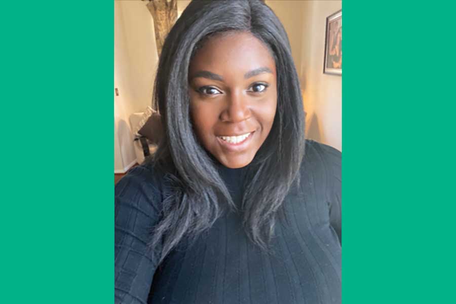 Portrait of a Black woman smiling wearing a black top.