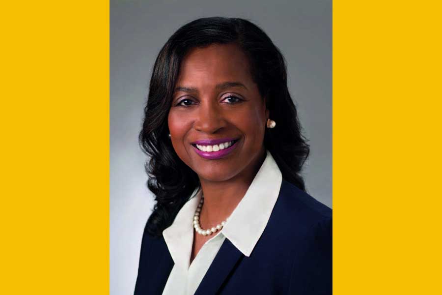 Portrait of a Black woman smiling wearing a business jacket.
