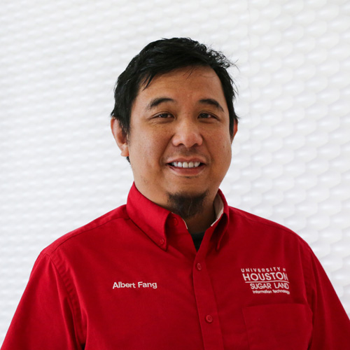 Portrait of an Asian man smiling with a goatee beard wearing a red button-up shirt
