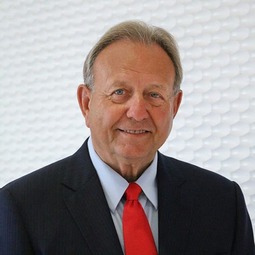 Portrait of an older man wearing a dark suit.