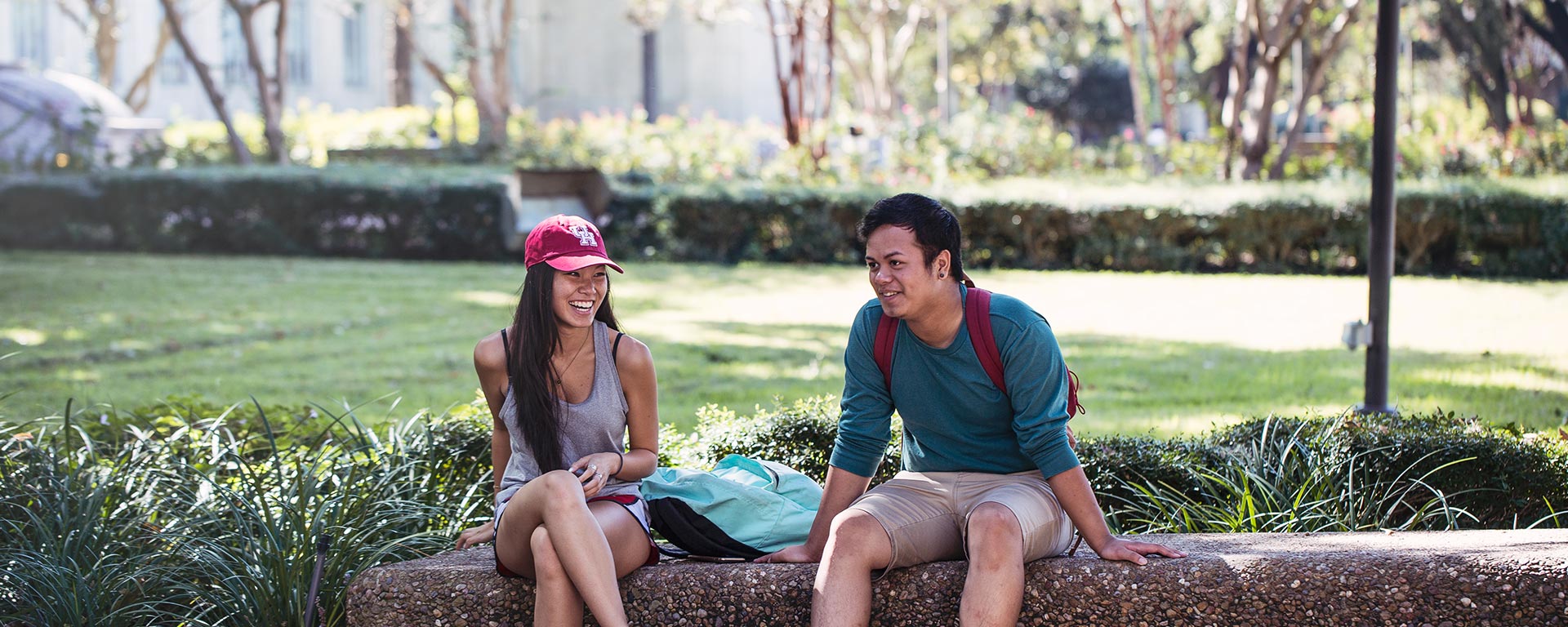 Two students sitting outside smiling
